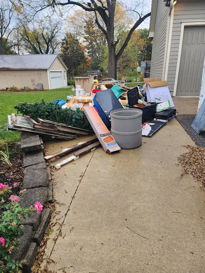 Dumpster being loaded with debris for 12 Yard Dumpster Rental in Burrillville